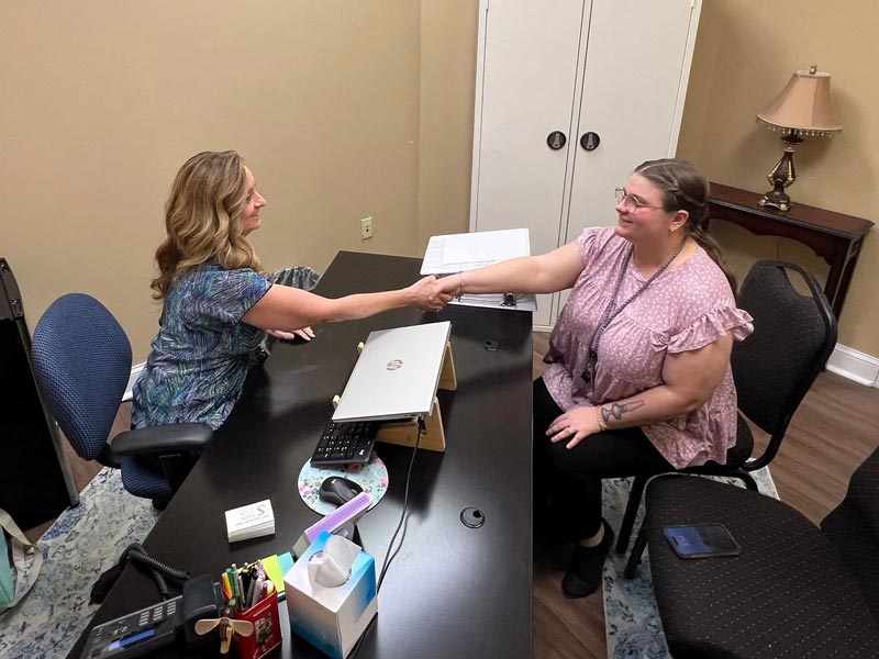 New employee prospect shaking hands with administrator